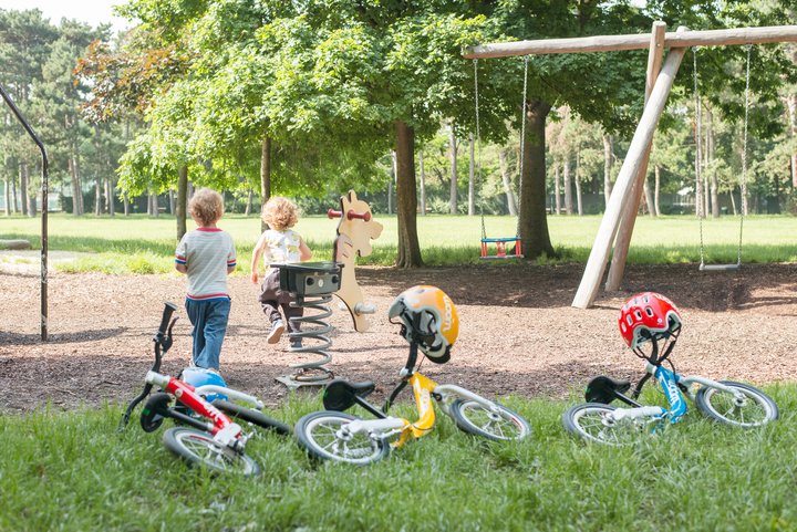 woom Fahrräder neben einem Spielplatz