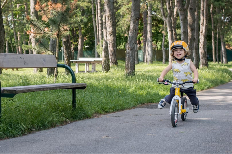 Kid on his yellow balance bike