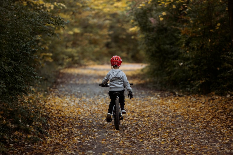 Kind mit woom Mountainbike im Wald