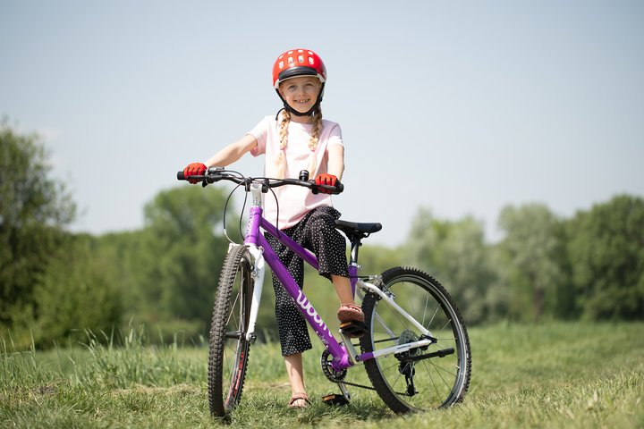 Mädchen mit violettem woom Fahrrad